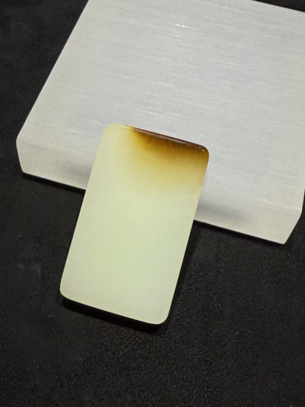 Uncarved white nephrite jade pendant with amber top