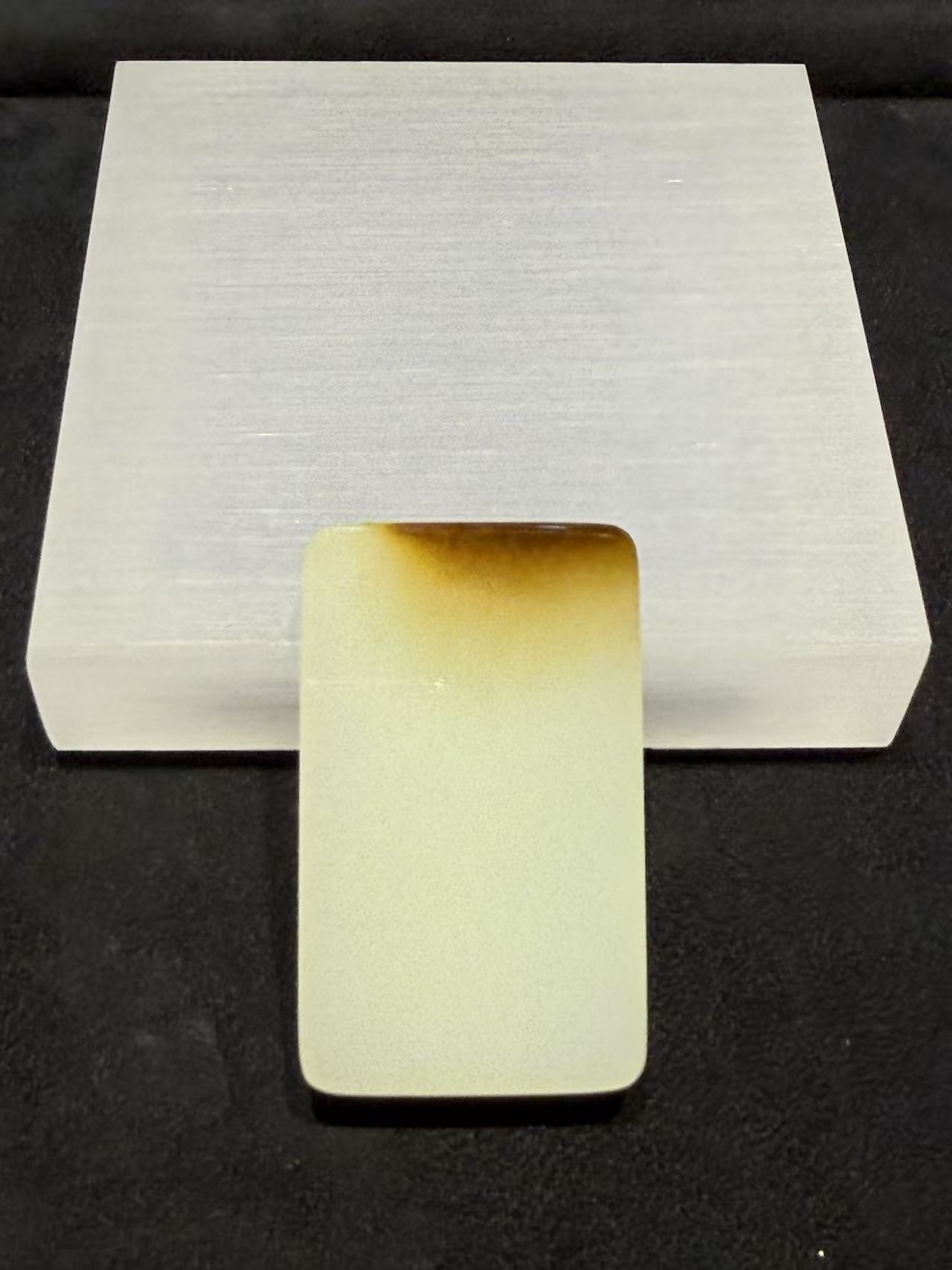 Uncarved white nephrite jade pendant with amber top