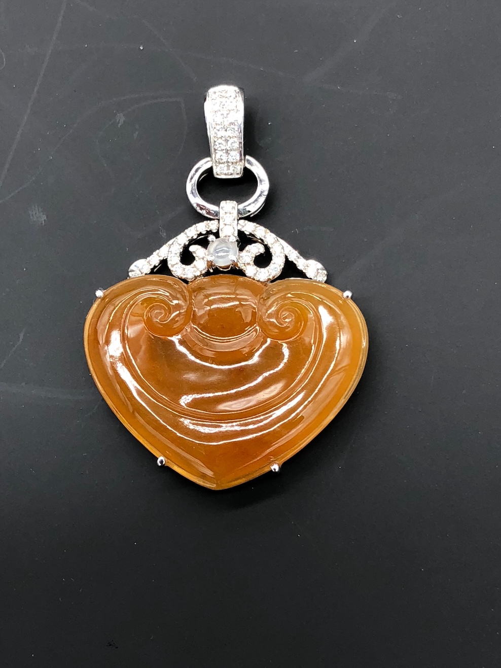 Translucent honey orange jadeite heart pendant with Ruyi carving, white gold setting and diamonds