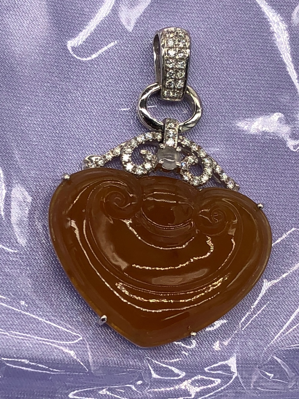 Translucent honey orange jadeite heart pendant with Ruyi carving, white gold setting and diamonds