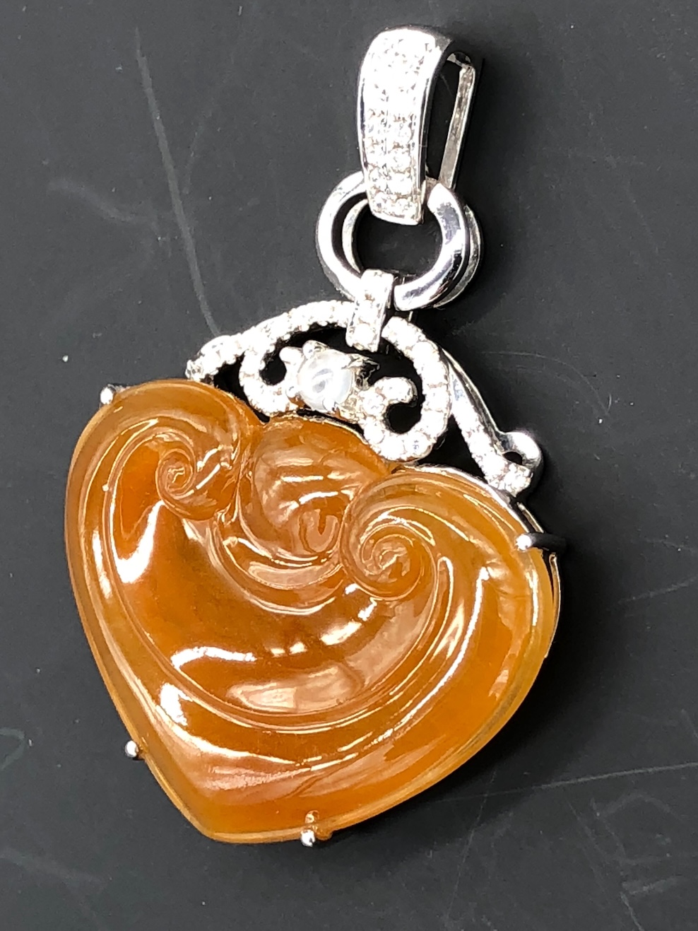 Translucent honey orange jadeite heart pendant with Ruyi carving, white gold setting and diamonds