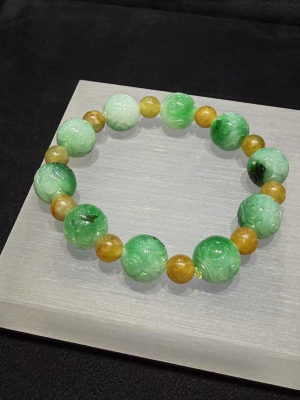 Translucent whitish green jade bracelet with Ruyi cloud carving and golden accent beads