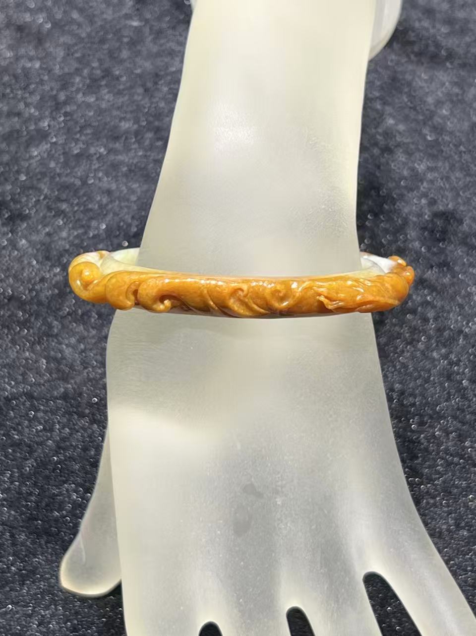 Translucent brownish-yellow jadeite bangle with hand-carved ruyi cloud scroll motifs symbolising fortune and continuity — Nanyang Jade Singapore