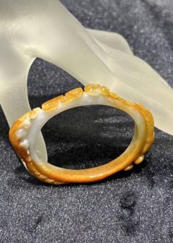 Translucent brownish-yellow jadeite bangle with hand-carved ruyi cloud scroll motifs symbolising fortune and continuity — Nanyang Jade Singapore