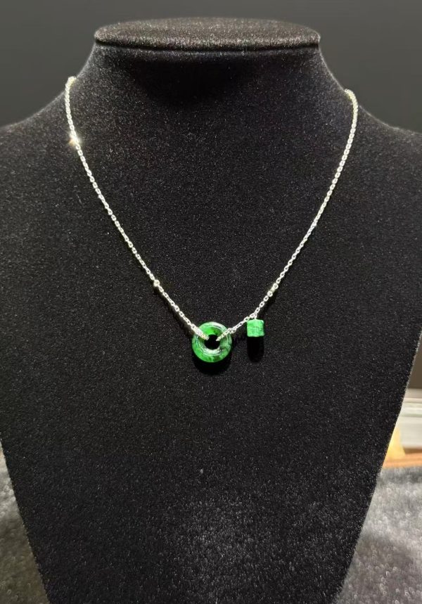 Translucent green jadeite safety knot pendant with dangling jade barrel on 18K white gold chain symbolising peace and protection — Nanyang Jade Singapore