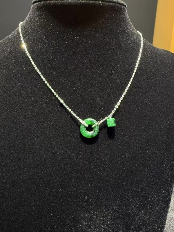 Translucent green jadeite safety knot pendant with dangling jade barrel on 18K white gold chain symbolising peace and protection — Nanyang Jade Singapore