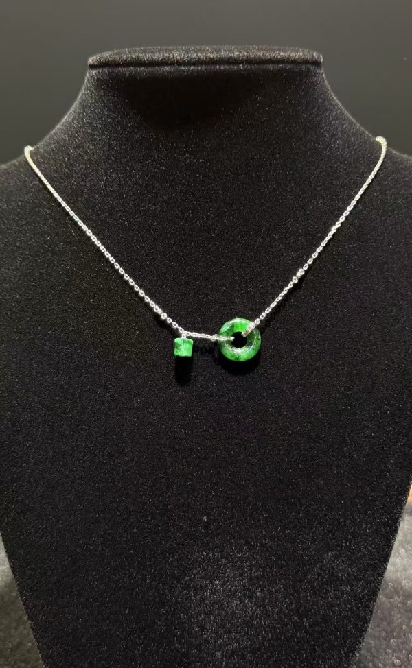 Translucent green jadeite safety knot pendant with dangling jade barrel on 18K white gold chain symbolising peace and protection — Nanyang Jade Singapore