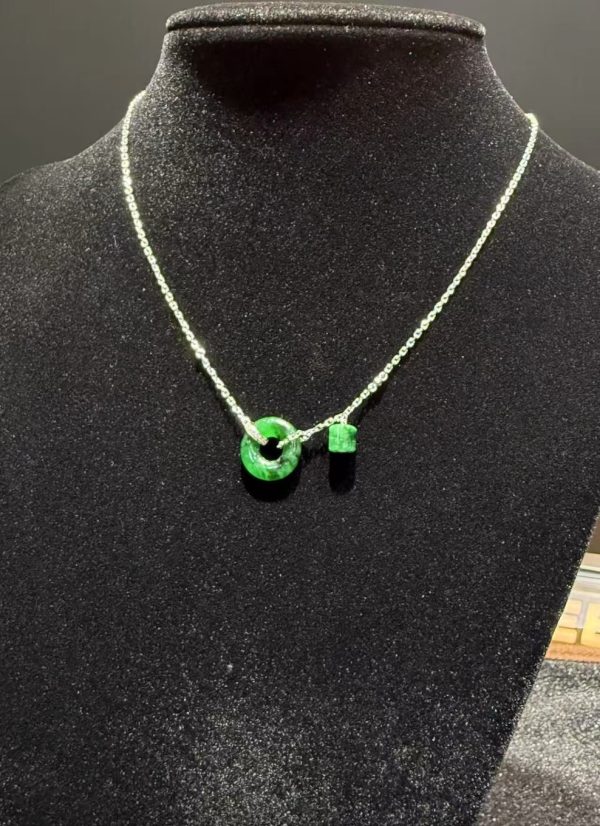 Translucent green jadeite safety knot pendant with dangling jade barrel on 18K white gold chain symbolising peace and protection — Nanyang Jade Singapore