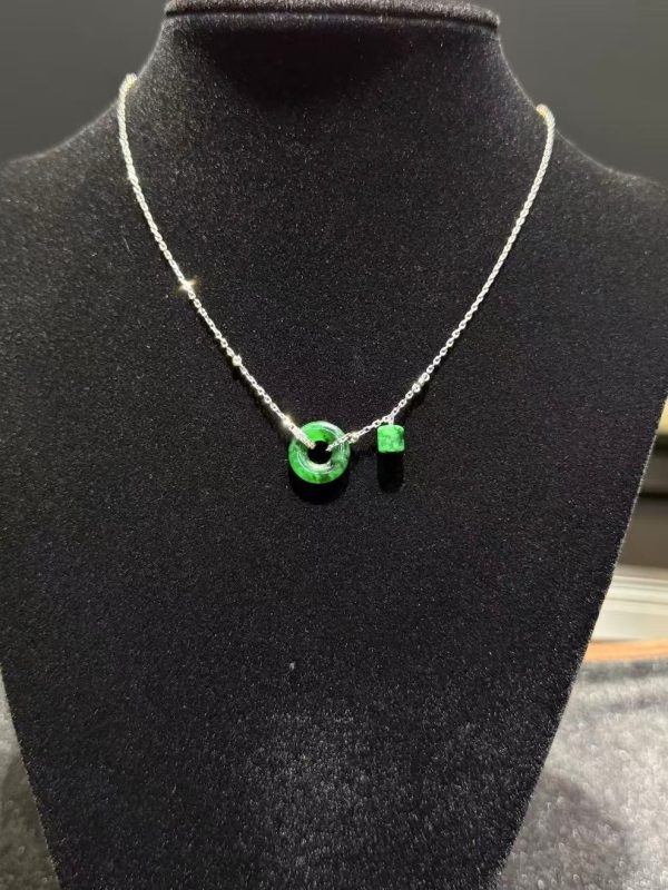 Translucent green jadeite safety knot pendant with dangling jade barrel on 18K white gold chain symbolising peace and protection — Nanyang Jade Singapore