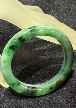 Translucent old pit green jadeite bangle in oval shape with vibrant emerald hues, natural Type A jade