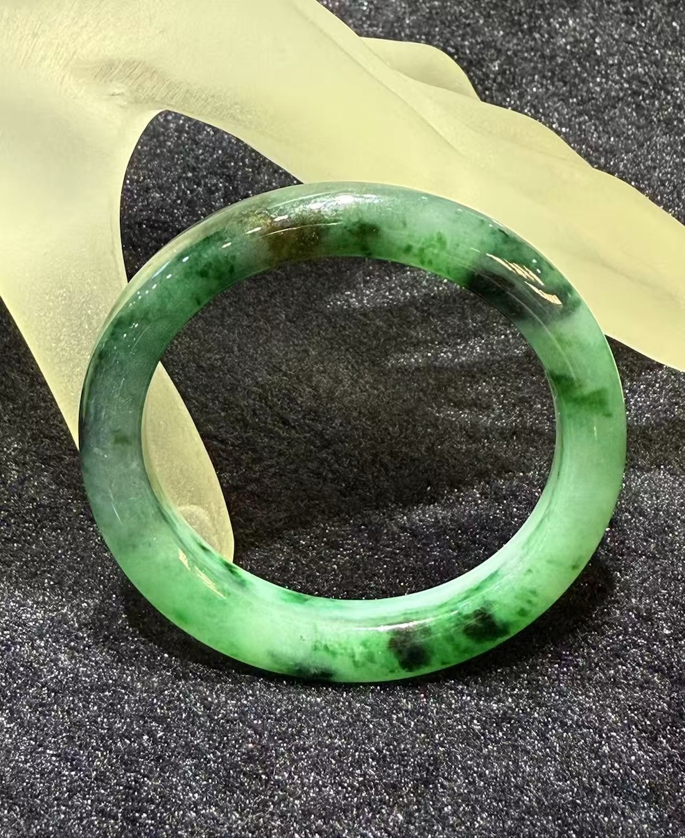 Translucent old pit green jadeite bangle in oval shape with vibrant emerald hues, natural Type A jade