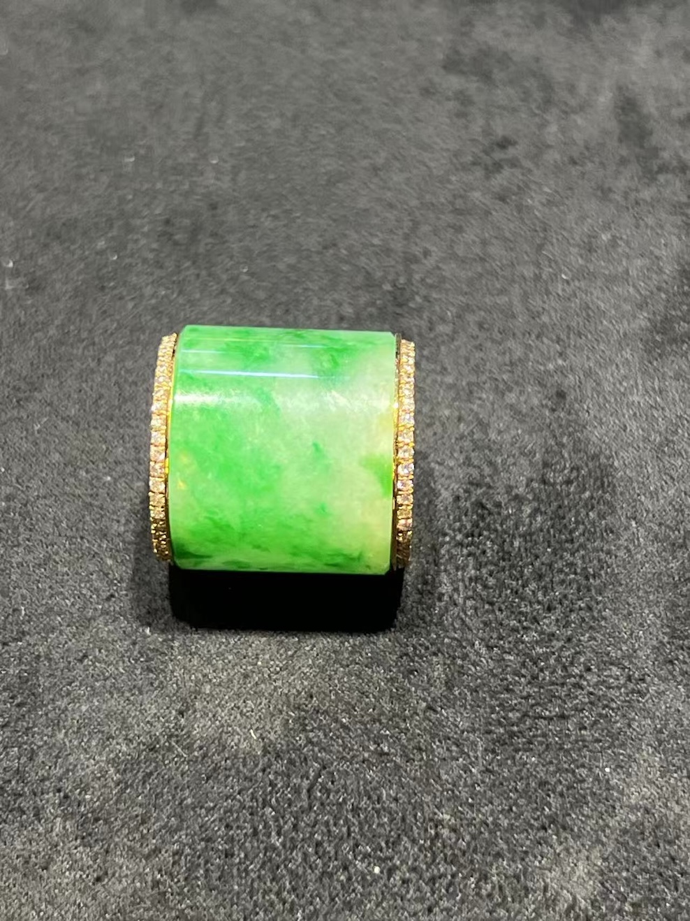 Translucent white-green jadeite barrel pendant set in 18K yellow gold with diamond rims, symbolizing prosperity and balance