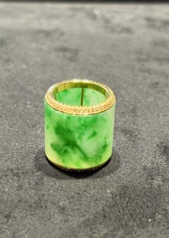 Translucent white-green jadeite barrel pendant set in 18K yellow gold with diamond rims, symbolizing prosperity and balance