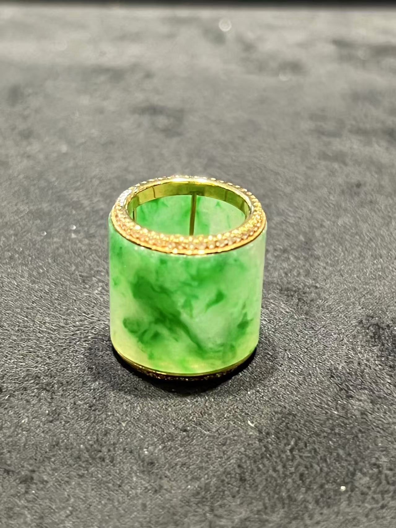 Translucent white-green jadeite barrel pendant set in 18K yellow gold with diamond rims, symbolizing prosperity and balance