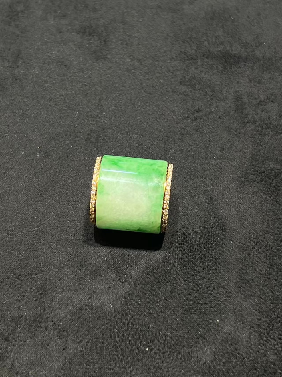 Translucent white-green jadeite barrel pendant set in 18K yellow gold with diamond rims, symbolizing prosperity and balance