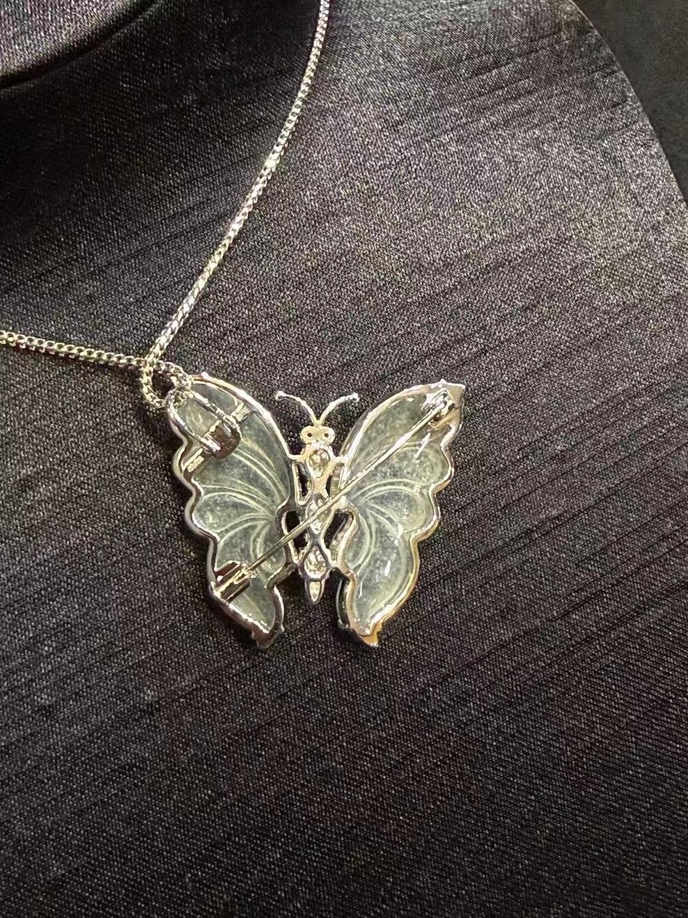 Highly translucent icy butterfly jadeite pendant and brooch with diamonds, pink sapphires, and green jade cabochons.