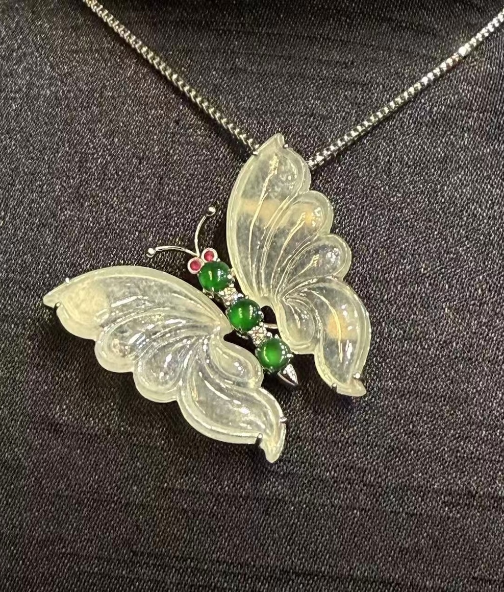 Highly translucent icy butterfly jadeite pendant and brooch with diamonds, pink sapphires, and green jade cabochons.