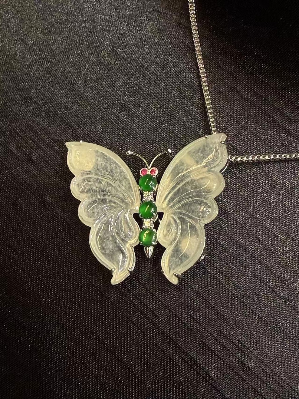 Highly translucent icy butterfly jadeite pendant and brooch with diamonds, pink sapphires, and green jade cabochons.