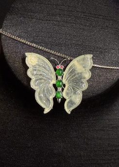 Highly translucent icy butterfly jadeite pendant and brooch with diamonds, pink sapphires, and green jade cabochons.