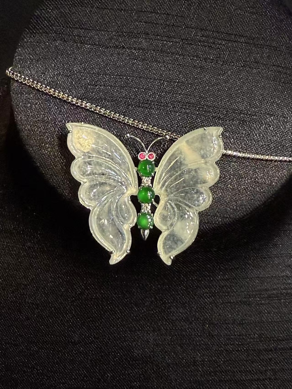Highly translucent icy butterfly jadeite pendant and brooch with diamonds, pink sapphires, and green jade cabochons.