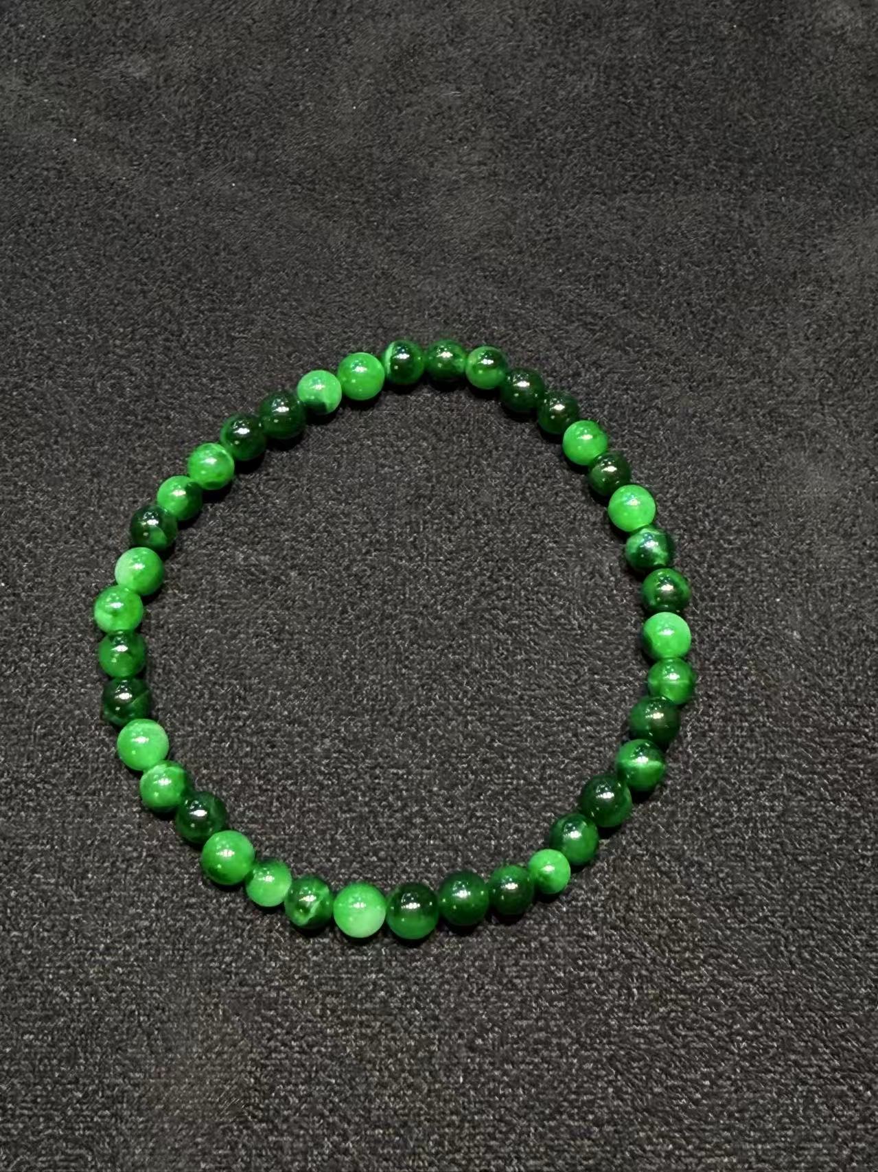 Translucent old pit green jadeite beads bracelet with natural Burmese jade in mixed green tones.