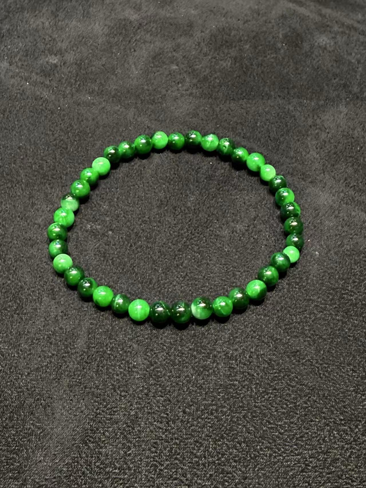 Translucent old pit green jadeite beads bracelet with natural Burmese jade in mixed green tones.