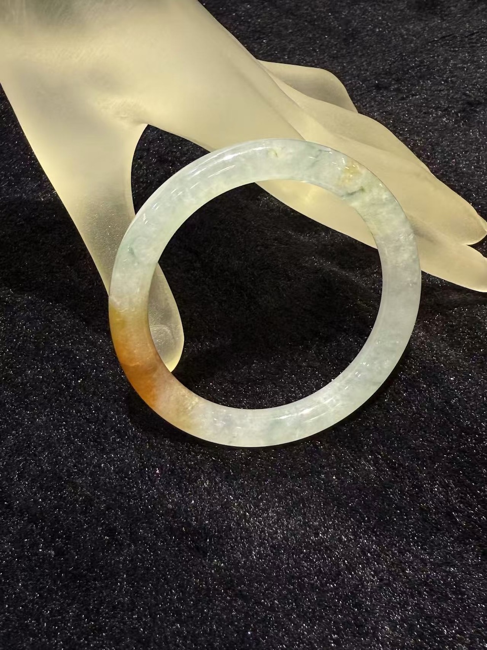 Highly translucent icy jadeite bangle with natural reddish patch