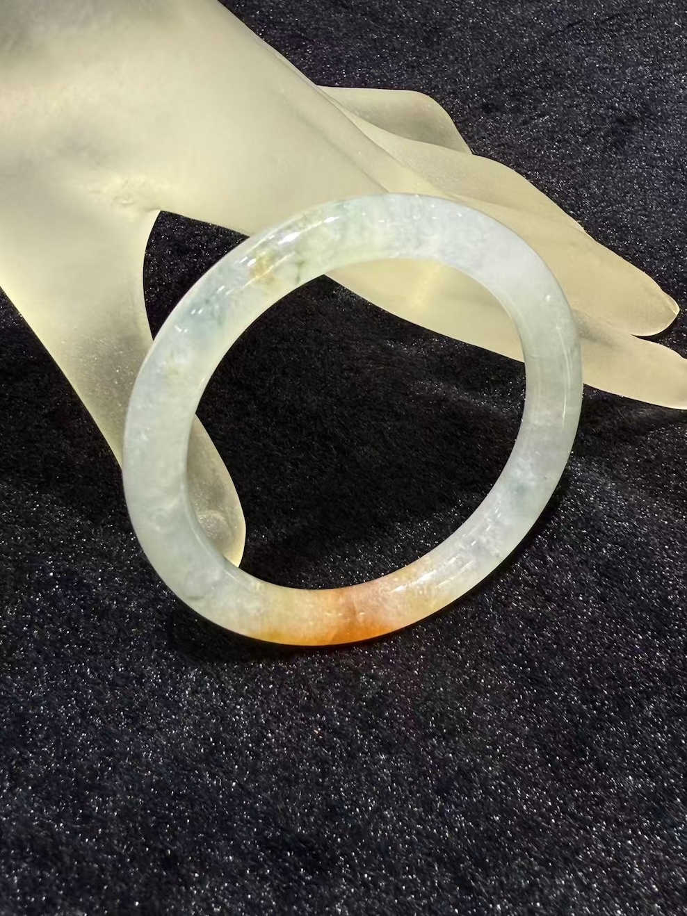 Highly translucent icy jadeite bangle with natural reddish patch