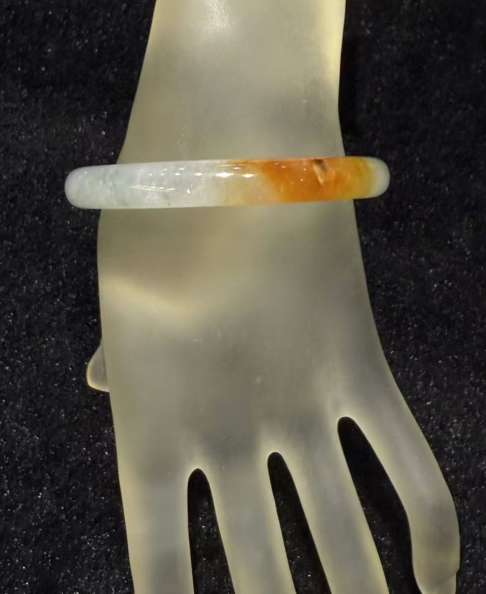 Highly translucent icy jadeite bangle with natural reddish patch