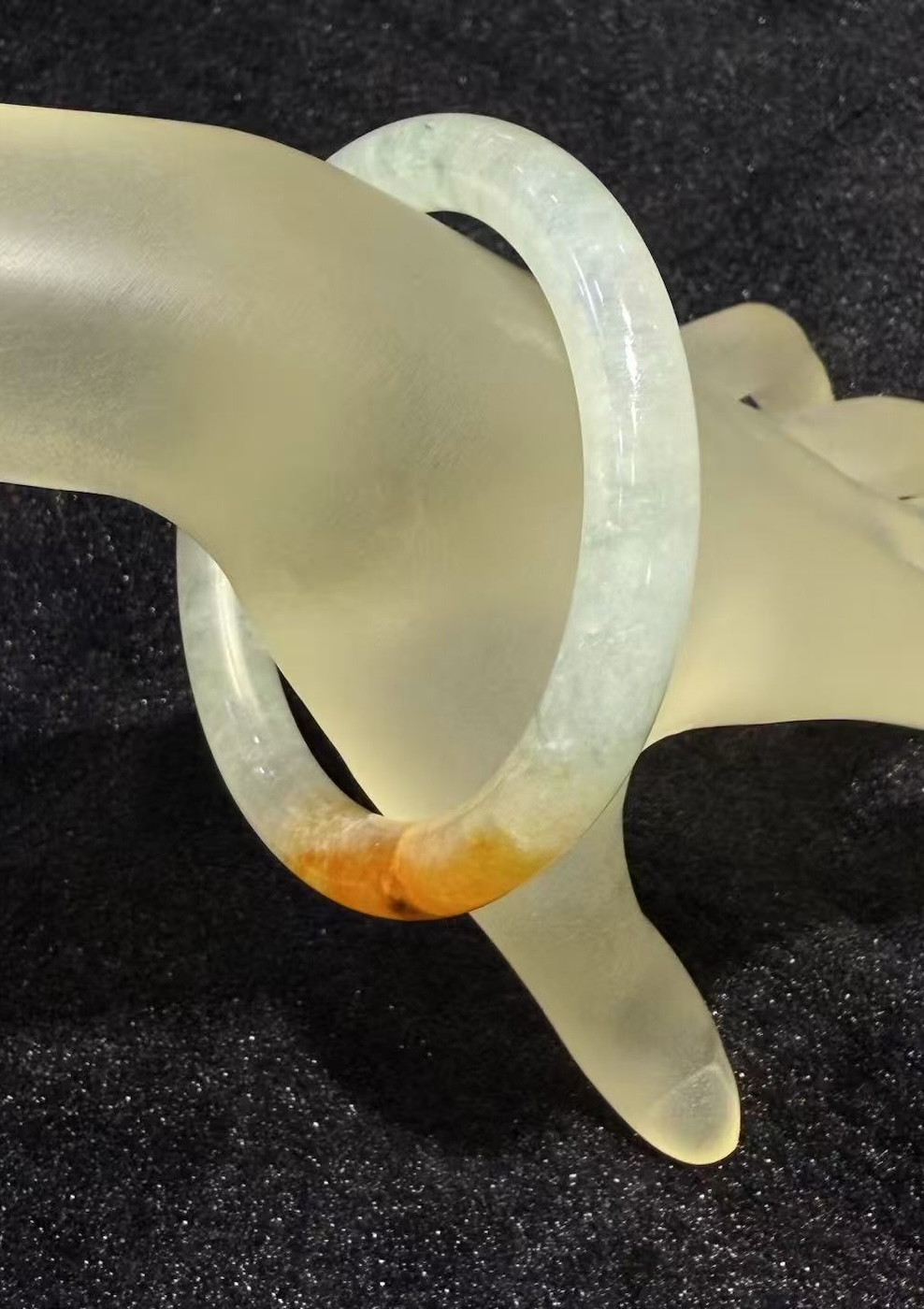 Highly translucent icy jadeite bangle with natural reddish patch