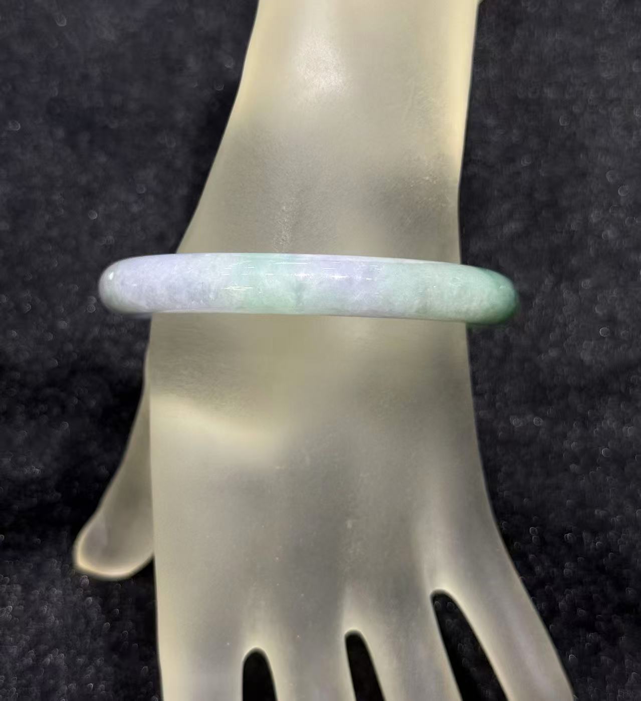 Translucent lavender jadeite bangle with natural green inclusions in classic round cut
