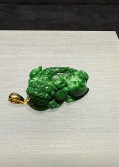 Vibrant green jadeite Pixiu pendant with detailed carving and gold bail