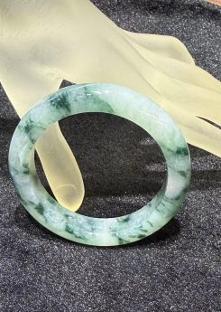 Blue-green floral jadeite bangle showing translucent texture