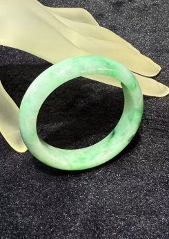 Natural Type A translucent white jadeite bangle with vibrant green patches