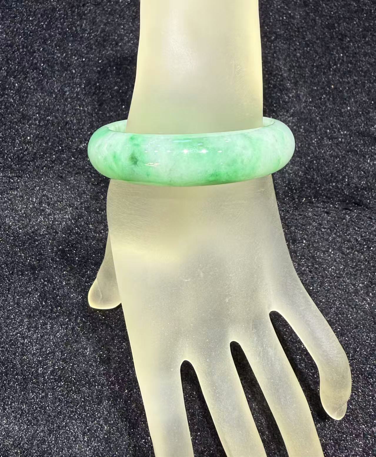 Natural Type A translucent white jadeite bangle with vibrant green patches