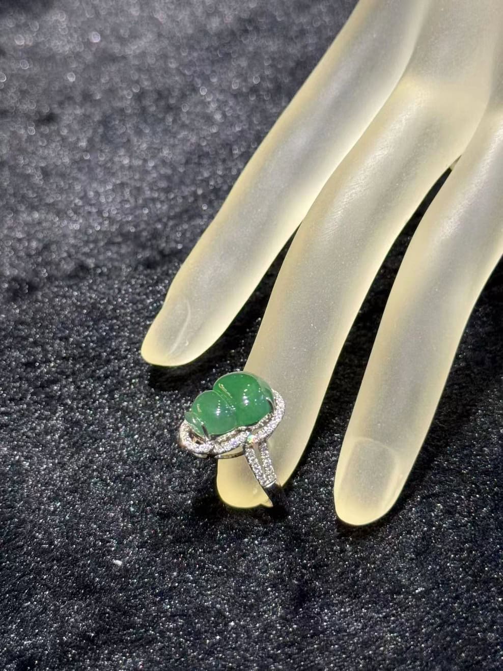 Jade gourd ring carved from icy translucent dark green jadeite, set in 18k white gold with a diamond halo and diamond-set shoulders