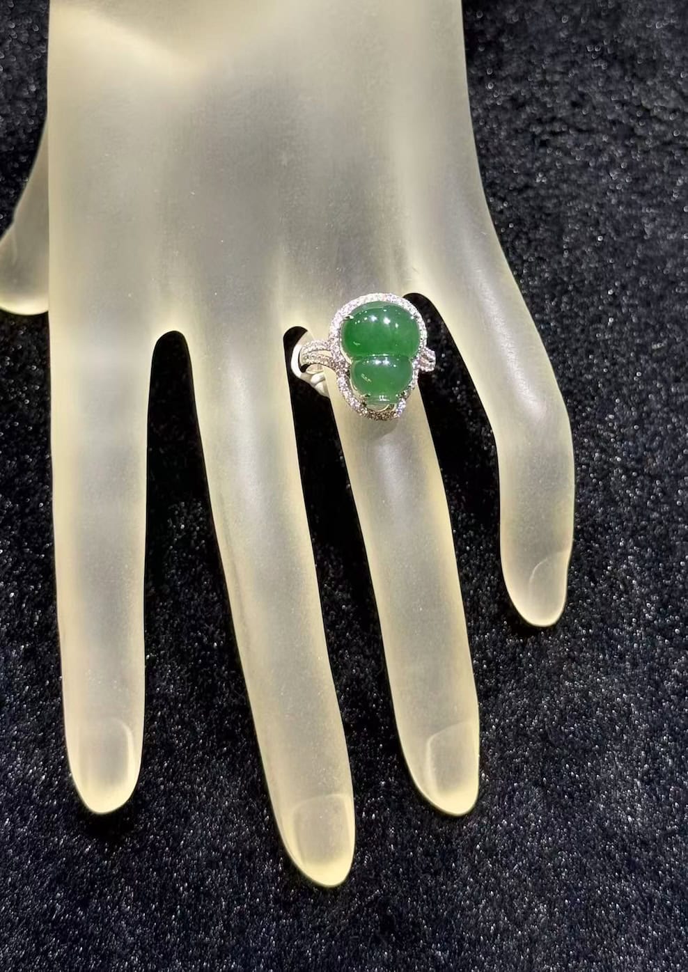 Jade gourd ring carved from icy translucent dark green jadeite, set in 18k white gold with a diamond halo and diamond-set shoulders