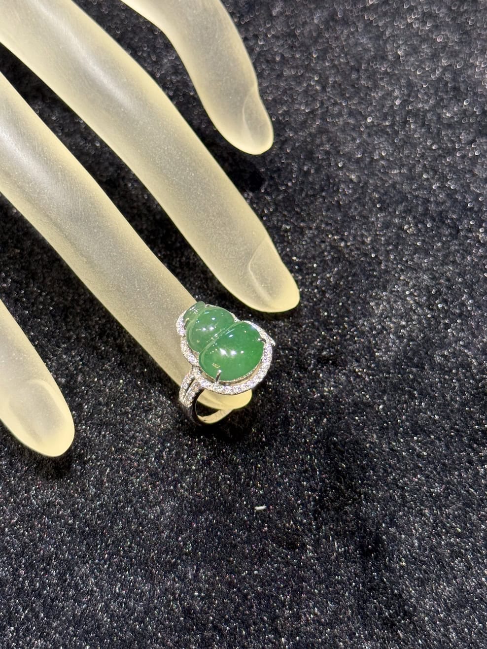 Jade gourd ring carved from icy translucent dark green jadeite, set in 18k white gold with a diamond halo and diamond-set shoulders