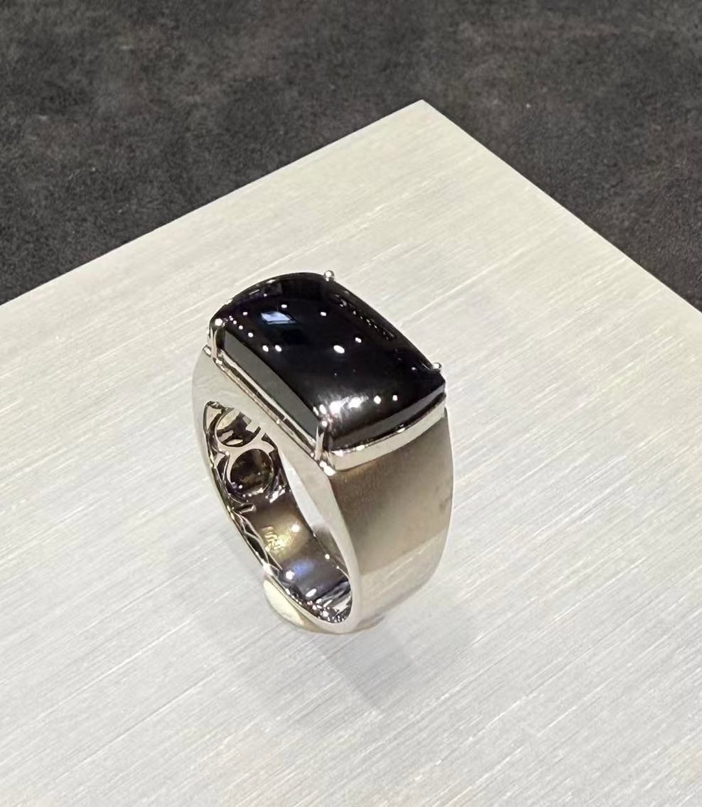 Black jade ring with a saddle-shaped omphacite cabochon that reads pure black under normal light, set in a polished 18k white gold band