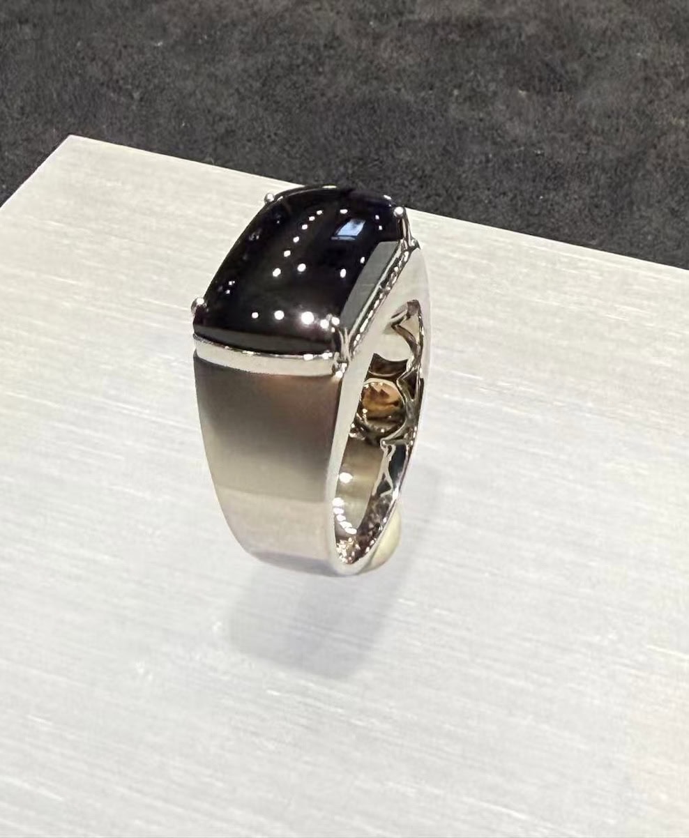 Black jade ring with a saddle-shaped omphacite cabochon that reads pure black under normal light, set in a polished 18k white gold band