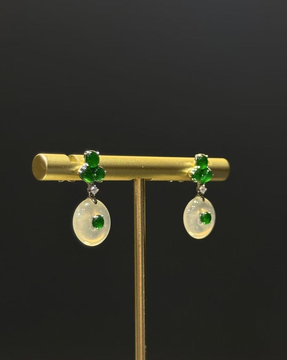Pair of jade drop earrings with highly translucent icy jadeite safety-buckle discs and vibrant green jadeite cabochons, set in 18k white gold with diamonds