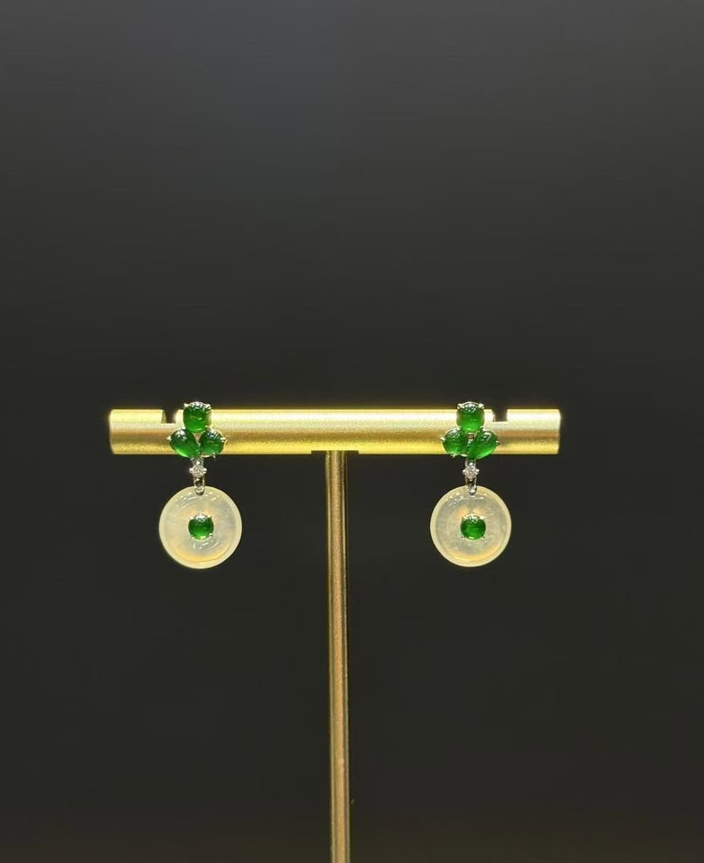 Pair of jade drop earrings with highly translucent icy jadeite safety-buckle discs and vibrant green jadeite cabochons, set in 18k white gold with diamonds