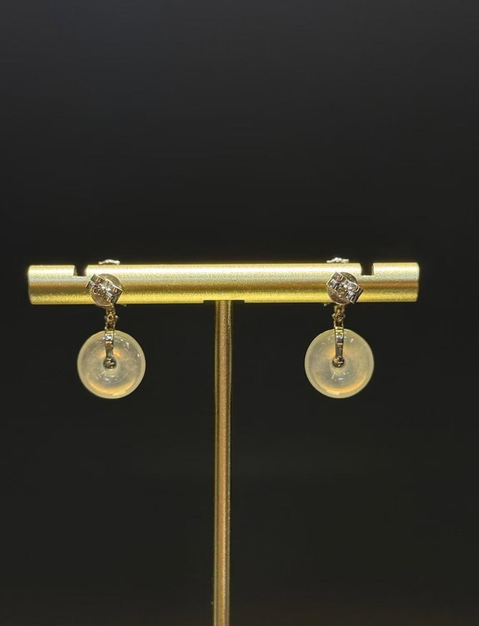 Pair of jade drop earrings with highly translucent icy jadeite safety-buckle discs and vibrant green jadeite cabochons, set in 18k white gold with diamonds