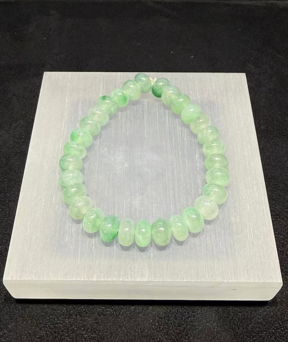 Jadeite abacus bracelet of icy, translucent jadeite beads with patches of vibrant green floating across the strand
