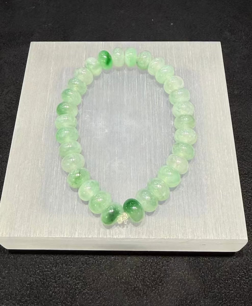 Jadeite abacus bracelet of icy, translucent jadeite beads with patches of vibrant green floating across the strand
