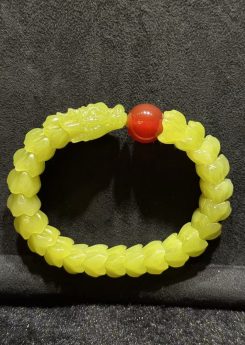 Yellow nephrite bracelet carved as a coiled dragon, with a detailed dragon head and scale-carved body, paired with a small red agate pearl bead