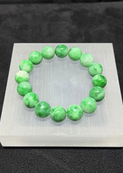 Apple green jadeite bracelet strung with round translucent vibrant apple-green jadeite beads, showing natural light and deeper green patches