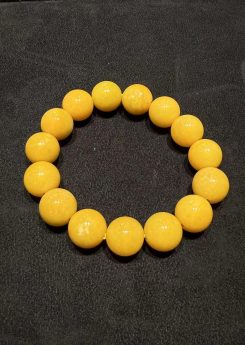 Honey jade bracelet strung with round translucent vibrant honey-yellow jadeite beads in a warm, even golden tone