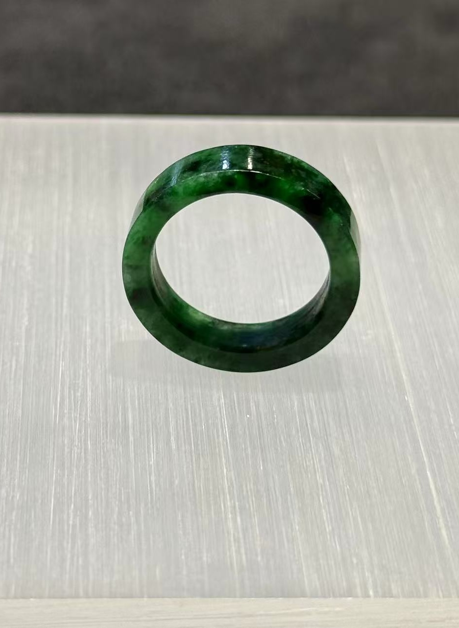Old pit jadeite ring carved as a solid band from a single piece of translucent vibrant green jadeite with deeper green patches and natural variation