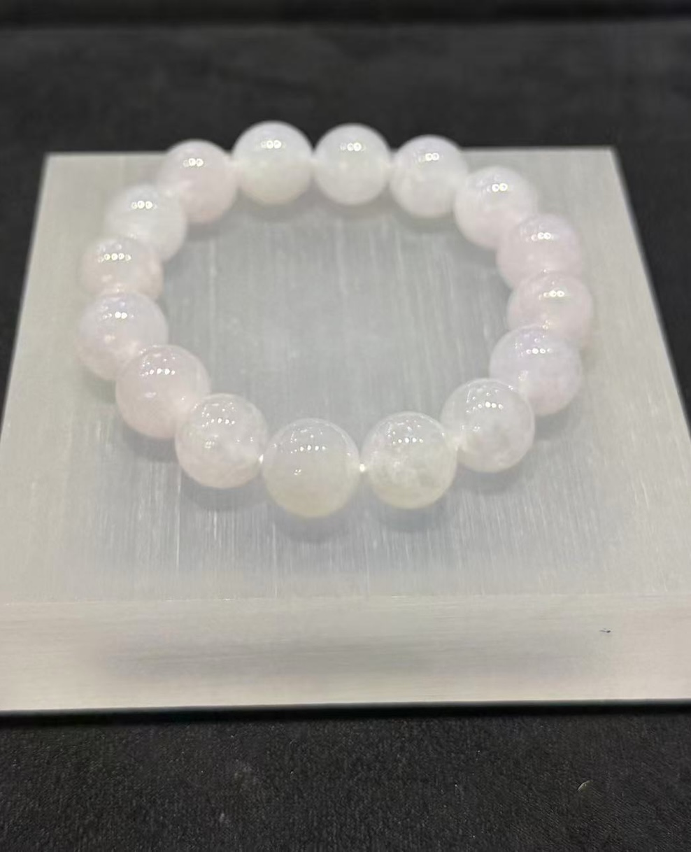 Lavender jade bracelet strung with round icy translucent jadeite beads in a whiteish body with a very faint lavender tint